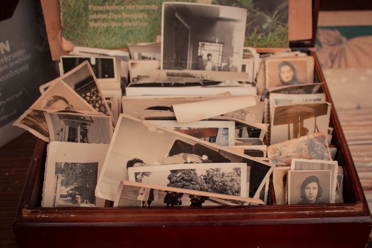 A wooden box overflowing with old family photographs
